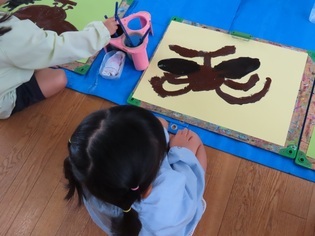カブトムシの絵を描いている子どもたちの写真