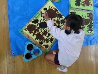 カブトムシの絵を描いている子どもたちの写真