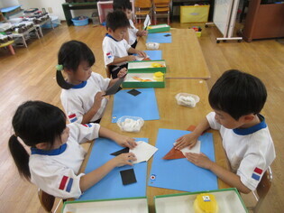 カブトムシを作っている子どもたちの写真