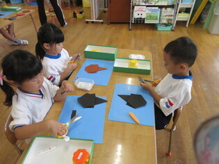 カブトムシを作っている子どもたちの写真