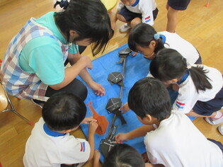 作ったカブトムシを見合っている子どもたちの写真