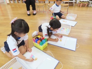 自分が着せたい服の色を選んでいる子どもたちの写真