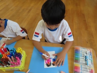 はがきを描いている子どもたちの写真
