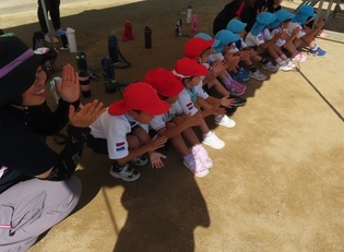 小学生の演技を見ている子どもたちの写真