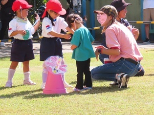 未就園児にペンダントをプレゼントをしている子どもたちの写真