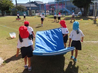 マットを運んで準備している子どもたちの写真